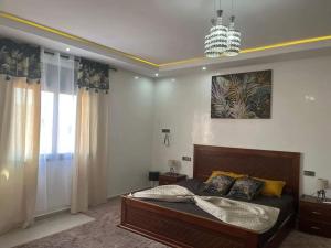 马拉喀什Villa Anis- VacayX - MARRAKECH的一间卧室配有一张大床和一个吊灯。