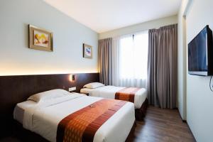 古晋56酒店的酒店客房设有两张床和一台平面电视。