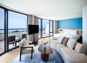 西归浦市Parnas Hotel Jeju的酒店客房设有一张特大号床和一间客厅。