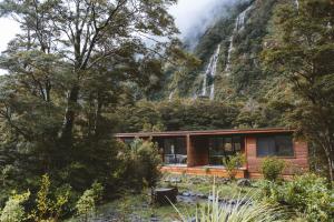 米尔福德峡湾Milford Sound Lodge的山间小屋,后方有瀑布