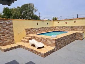阿拉鲁阿马Casa em Condomínio com Piscina Privativa的砖墙中一个带长凳和水槽的游泳池