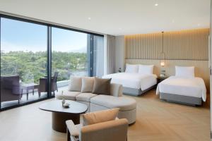 西归浦市Parnas Hotel Jeju的酒店客房,设有两张床和一张沙发