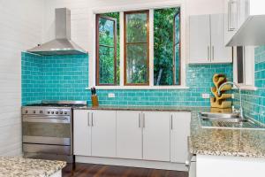 拜伦湾A Perfect Stay - Skye Lodge的厨房配有白色橱柜和蓝色瓷砖