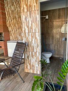 PalmasPousada Luciana Dias的庭院中设有带卫生间和椅子的浴室