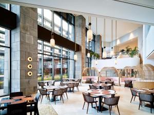 西归浦市Parnas Hotel Jeju的餐厅设有桌椅和窗户。