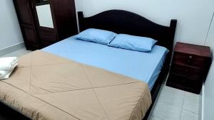 万象CS Apartment的一间卧室配有一张带蓝色枕头的床和床头柜
