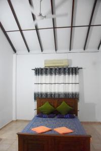 马哈拉贾马Maharagama Shehan Hotel的一间卧室配有一张带绿色枕头的床