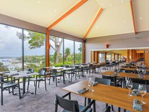 斯特拉恩斯特拉汉村酒店的餐厅设有桌椅和大窗户。