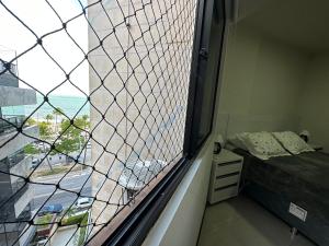 马塞约Apartamento á beira mar em Maceió的窗户,带床和窗户的房间