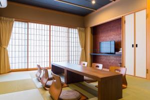 大阪Ryokan Suzuran Tengachaya的一间带木桌和椅子的用餐室