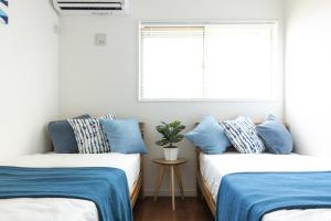 三浦市The Beach Front Miurakaigan - Vacation STAY 10780的配有两张床铺的蓝色和白色枕头