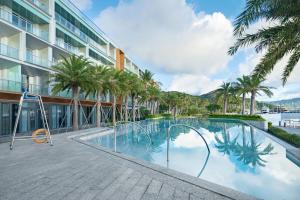 深圳深圳浪骑瞻云度假酒店的一座棕榈树游泳池和一座建筑