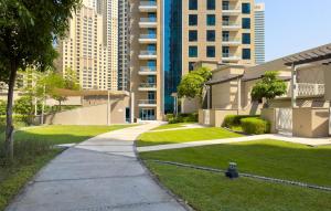 迪拜Boutique Apartment Sea Views - Dubai Marina的人行道,在有草和建筑物的建筑前