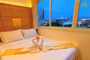 芭堤雅市中心The Grand Lodge Pattaya的一张带两个天鹅的毛巾床
