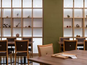 熊本熊本三井花园酒店的一间带木桌、椅子和架子的餐厅