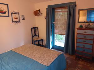 米拉玛Casa de campo, surf, pesca y golf的一间卧室配有一张床、一个梳妆台和一扇窗户。