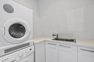 墨尔本Boutique Stays - Port Haven的白色的厨房配有水槽和洗衣机