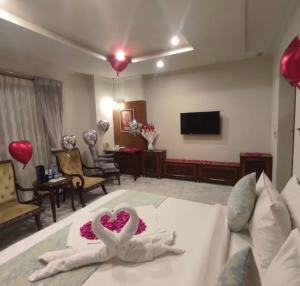 伊斯兰堡Sintra Hotel的一间酒店客房,床上放着两个心