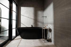 沃加沃加St Hugh Hotel Wagga Wagga的带窗户的浴室内的黑色浴缸