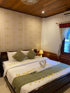 琅勃拉邦金莲花广场宾馆的一间卧室配有两张鲜花床。