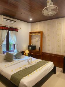 琅勃拉邦金莲花广场宾馆的一间卧室配有一张大床和镜子