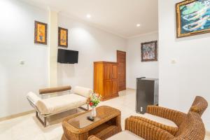 克拉玛斯Nirmala Guest House Surf Keramas的客厅配有椅子、沙发和电视