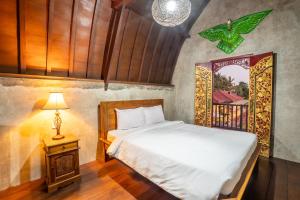 克拉玛斯Nirmala Guest House Surf Keramas的一间卧室配有床、灯和窗户
