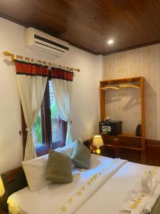 琅勃拉邦金莲花广场宾馆的一间卧室设有一张大床和一个窗户。