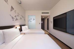 新加坡Aloft Singapore Novena的一间酒店客房,配有一张白色大床和一台平面电视