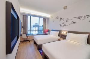 新加坡Aloft Singapore Novena的酒店客房设有两张床和一台平面电视。