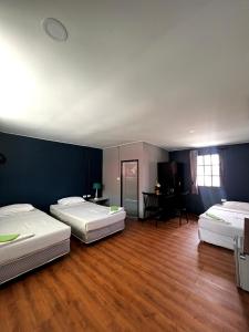 皮皮岛皮皮岛酒店的铺有木地板,拥有蓝色墙壁,配有三张床。