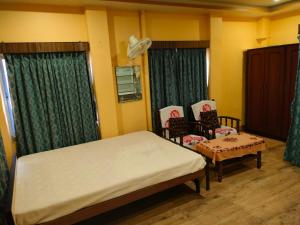 加尔各答Kanan Villa的一间卧室配有一张床和两把椅子