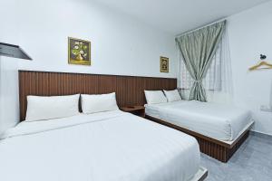阿罗士打Capital O 90882 Padi Hotel的酒店客房设有两张床和窗户。