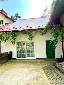 约瑟夫乌Sosnowy apartament的白色的房子,设有绿色的门和窗户