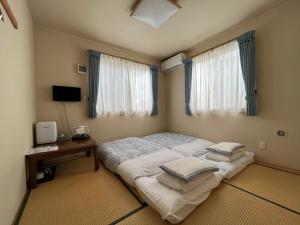 成田Karin doo Hotel的一间卧室配有一张大床和枕头