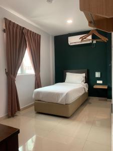 峇株巴辖Room V by SECOM Jalan Megat的一间卧室设有一张床和绿色的墙壁