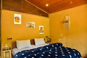 比尔瓦Monkey Mud House and Camps, Bir的一间卧室设有一张床和黄色的墙壁