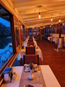 希莱agva temmuz otel的餐厅设有白色的桌椅和窗户。