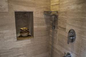 乌奇希萨尔Ages in Cappadocia的浴室里设有玻璃门和花瓶淋浴