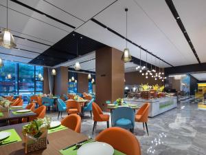 深圳深圳宝安机场希尔顿欢朋酒店的餐厅的 ⁇ 染,配有桌椅