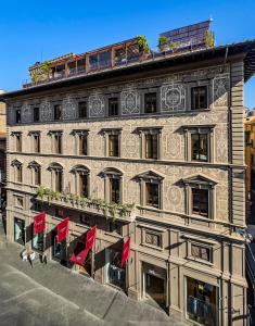 佛罗伦萨Hotel Calimala的前面有红旗的建筑