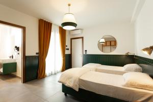 加拉托内加拉酒店的一间卧室配有两张床和镜子