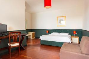 加拉托内加拉酒店的一间卧室配有一张床和一张书桌及电视
