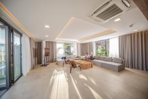 芽庄Nha Trang Oceanfront Luxury Villa Anh Nguyen的客厅,沙发上设有两人座位