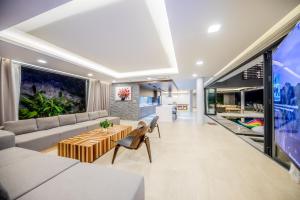 芽庄Nha Trang Oceanfront Luxury Villa Anh Nguyen的客厅配有沙发和桌子