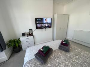 Harrow on the HillDouble Bedroom with TV in Sudbury Hill Wembley - 10 mins from Wembley Stadium的卧室配有一张床铺,墙上配有电视