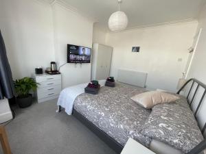 Harrow on the HillDouble Bedroom with TV in Sudbury Hill Wembley - 10 mins from Wembley Stadium的卧室配有一张床,墙上配有电视。