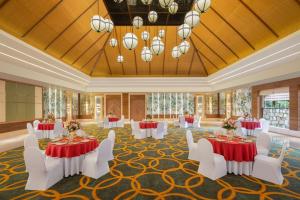 布什格尔Ananta Spa & Resort, Pushkar的一个带桌子和白色椅子的宴会厅和一个大房间
