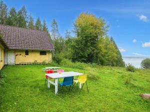 斯坎讷堡5 person holiday home in Skanderborg的坐在房子旁边的草坪上的桌椅