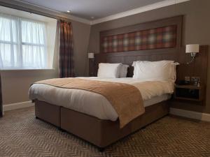莱特肯尼迪龙酒店的卧室配有一张带白色床单和枕头的大床。